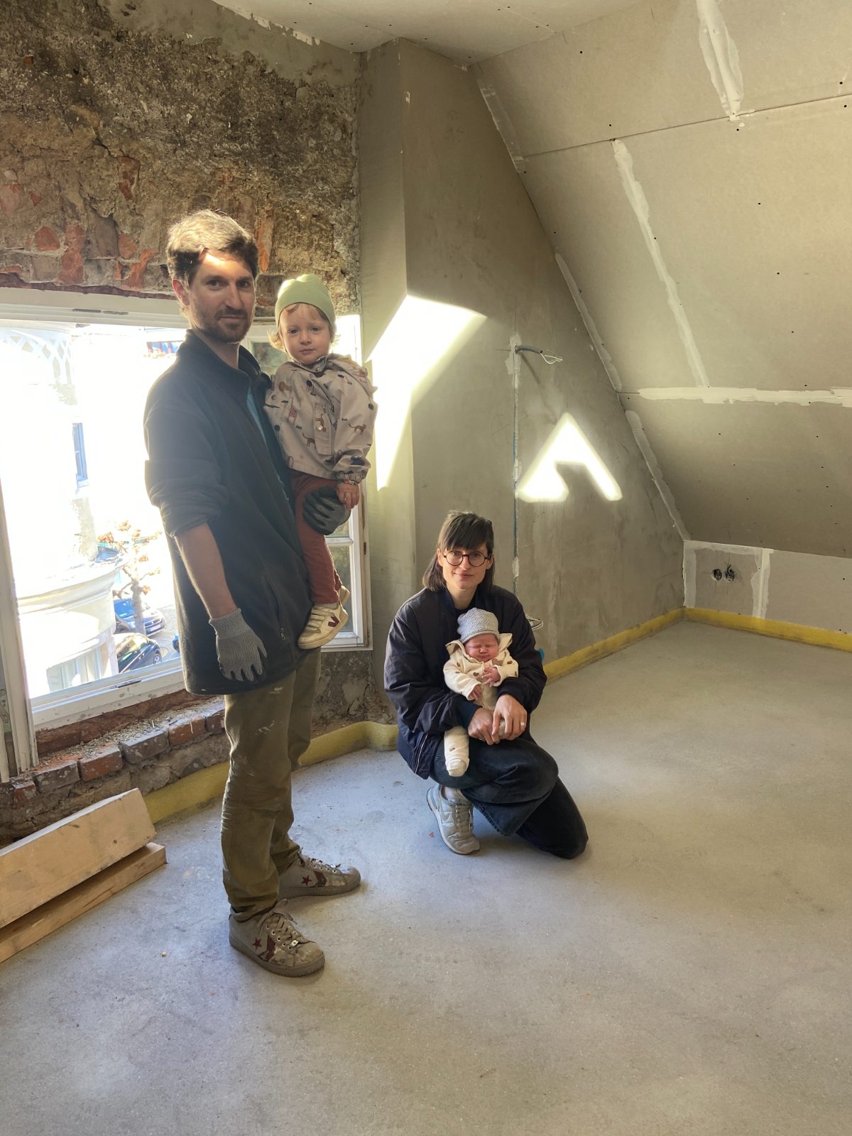Die Familie mit beiden Kindern auf der Baustelle im Dachgeschoss